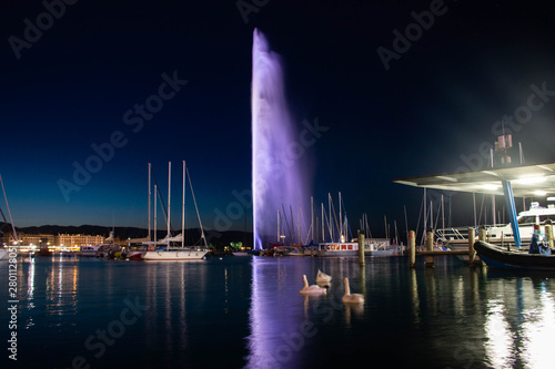 Long exposure capture of the Jet d'eau with swans swimming in a boat yard in Geneva Switzerland 