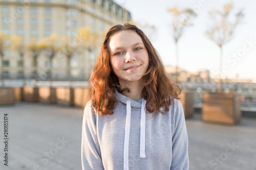 Outdoor portrait of beautiful smiling teenager girl 14, 15 years old