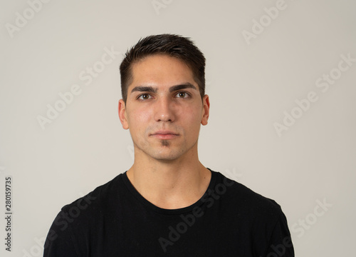 Natural portrait of young attractive man in his 20s looking and posing with neutral face expression