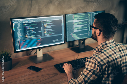 Profile side view of his he nice bearded guy wearing checked shirt professional expert html data base structure screen at wooden industrial interior work place station