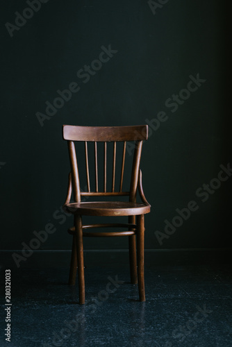 Old-fashioned wooden chair on a dark background in the interior