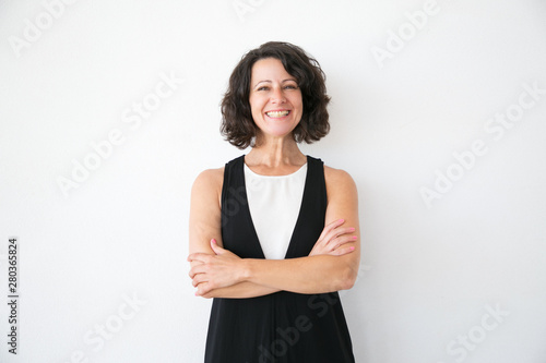 Happy joyful woman in casual posing over white studio background. Portrait of cheerful successful middle aged business lady with arms folded smiling at camera. Female portrait concept