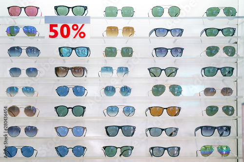 Stand with sunglasses. Sale at a discount of 50% at the city market or in the store sunglasses. Trendy sunglasses, Summer eyeglasses, fashion collection, Different sunglasses on a stand.