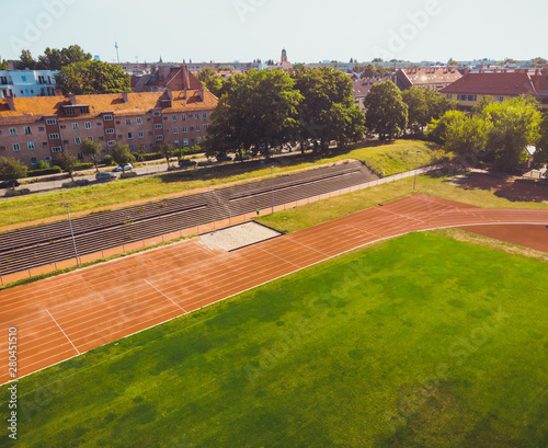 stadium with green grass and red running line