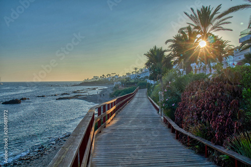 Puente sobre arena en playa con vistas al mar