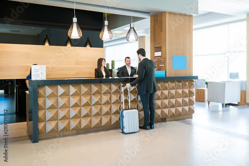 Happy Hotel Clerks Are Welcoming Professional At Counter