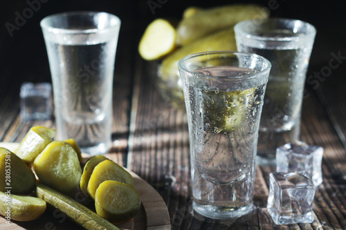 Three shots with vodka and pickled cucumbers 