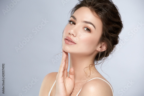 fresh woman face with glossy lipstic and light make-up looking to camera