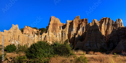 Earth Forest of Yuanmou in Yunnan Province, China - Exotic earth and sandstone formations glowing in the sunlight. Naturally formed pillars of rock and clay with unique erosion patterns. China Travel