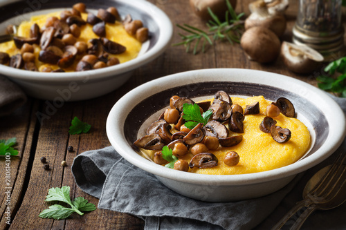 Traditional Italian polenta or boiled cornmeal with mushrooms and chickpeas garnished with fresh parsley