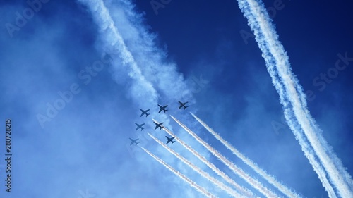 airshow in sky by bright sea and traced lines