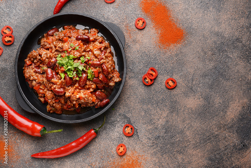 Frying pan with tasty chili con carne on grey background