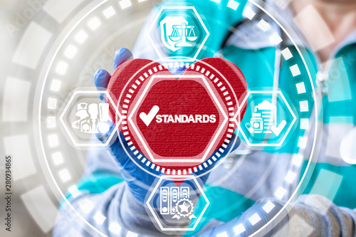 Standards Quality Medicine concept. Doctor holding red heart and standards check mark icon on virtual interface. Healthcare Control Regulation.