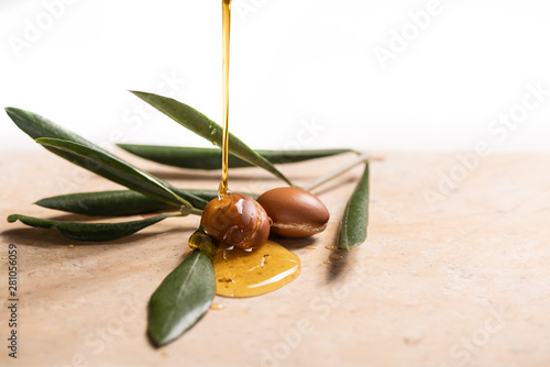 argan oil pouring over argan seeds