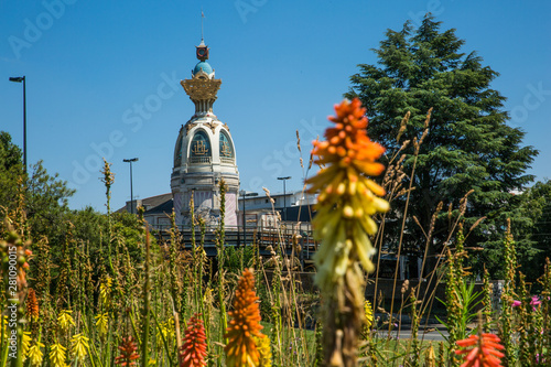 Tour Lu in Nantes on a Sunny Summer Day with Green Vegetation and Orange Common Torch Lilly Flowers