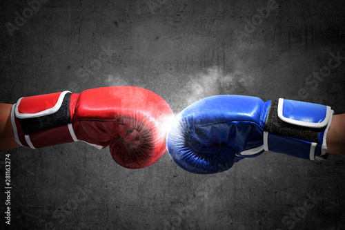 Hands of two men with blue and red boxing gloves bumped their fists