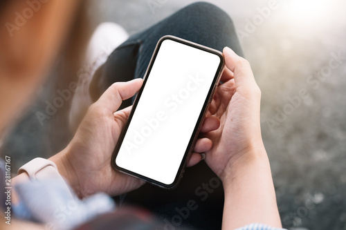 Top view Woman sitting and holding blank screen mock up mobile phone