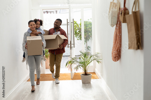 Family with cardboard boxes entering their new home