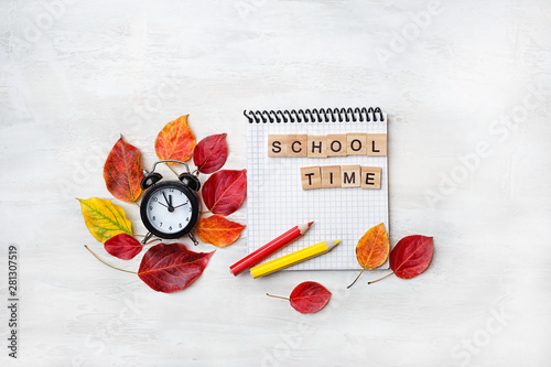 school time concept. notebook, pencil, clock alarm, autumn leaves. Concept of education, starting school, back to school. 1 september. beginning of school year. copy space