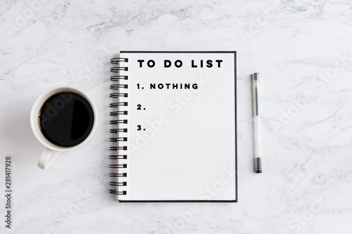 To do list nothing writing on notebook. Notebook on desk with coffee cup and a pen.