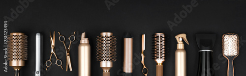 Collection of professional hair dresser tools arranged on dark background