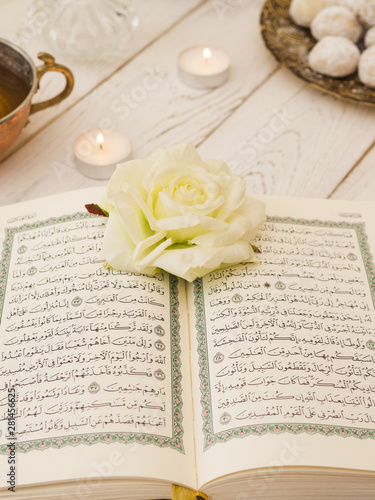 Top view opened quran with white rose
