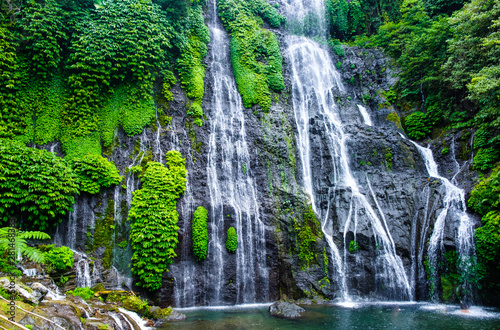 Banyumala Twin Waterfalls. Jungle waterfall cascade in tropical rainforest with rock and turquoise blue pond. Bali, Indonesia. 