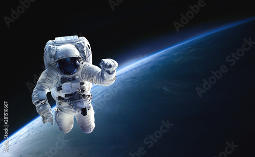 Astronaut in the outer space over the planet Earth. Abstract wallpaper. Spaceman. Black bakground. Elements of this image furnished by NASA
