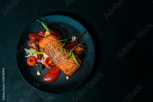 Delicious meal on a black plate, top view, copy space.