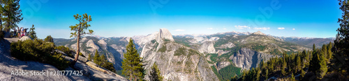 Yosemite National Park, California / USA - September 2nd, 2012: Panoramic view from the Glacier Point with the Half Dome in the center / Some visitors watching the views from a viewpoint telescope