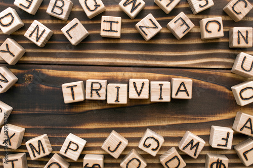 trivia - word from wooden blocks with letters, unimportant concept, random letters around, top view on wooden background