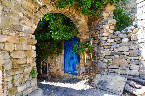 An arched alley in the medieval village of Bussana Vecchia, former ghost town in Ligurian Riviera with stone buildings ruined from an earthquake in 1887 and now repopulated by artists, Imperia, Italy