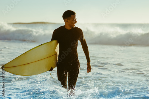 Surfer coming out of the ocean