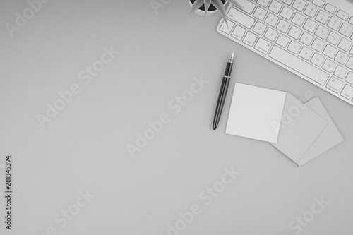 Flat lay, top view office table desk. Workspace with pen, sticky notes, decoration vase and keyboard on Black and White. Business Finance, Education and Copy Space concept