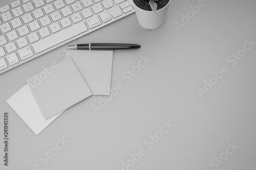 Flat lay, top view office table desk. Workspace with pen, sticky notes, decoration vase and keyboard on Black and White. Business Finance, Education and Copy Space concept