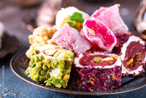 Bowl with various pieces of turkish delight lokum on a dark background. Close up