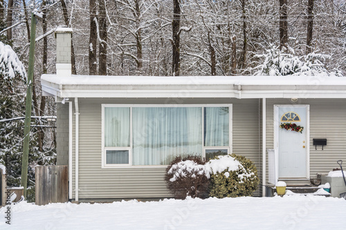 Entrance of residential house with front yard in snow on winter day