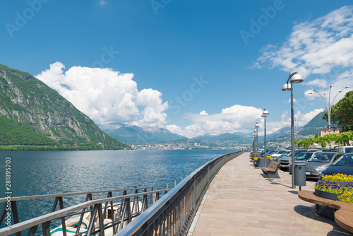 Lake Lugano and Campione d'Italia, Italy. City known for the casino. Lakefront promenade and the city of Lugano in the background, summer landscape