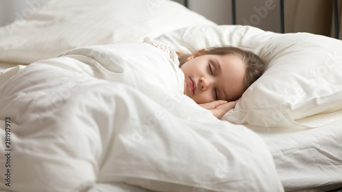 Sweet little kid girl having healthy day nap in bed