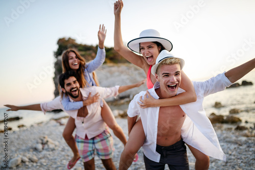 Cheerful friends enjoying weekend and having fun on beach