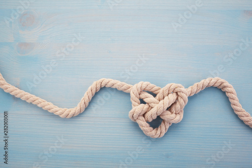 Heart shaped knot on blue wooden background