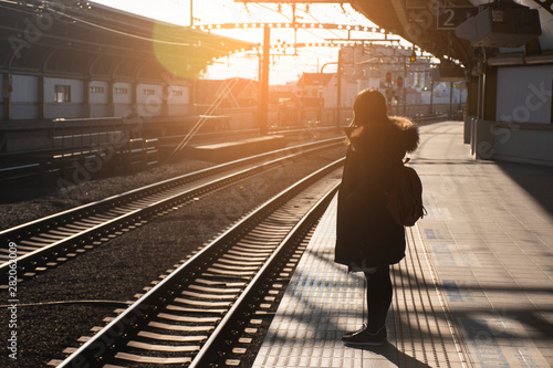 A woman is waiting the train at the station in Japan.