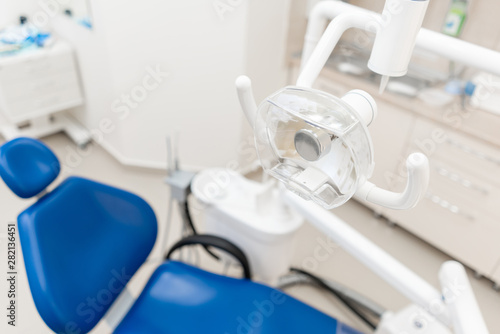 Close-up dentist lamp. Dental work in clinic. Operation, tooth replacement. Medicine, health, stomatology concept. Office where dentist conducts inspection and concludes.