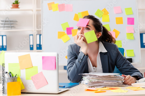 Young female employee in conflicting priorities concept