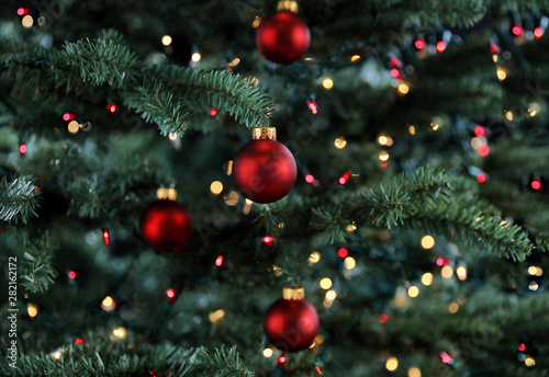 Glowing Christmas tree decorated with red and gold ornament balls for the holiday season 