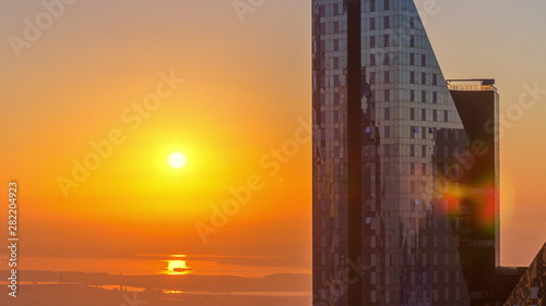 Sunrise over Dubai skyline in the morning, aerial top view to downtown city center landmarks timelapse.