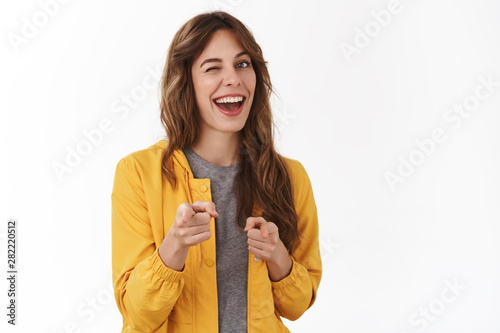 Gotcha. Hey wanna be friends. Cheeky confident relaxed young party girl smiling broadly winking approval pointing camera finger pistols you nice work gesture approve great choice, white background