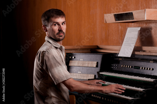 Bearded man playing trumpet organ