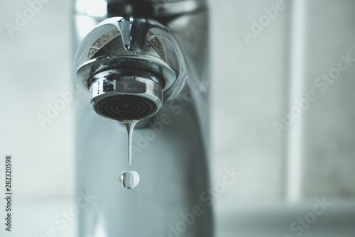 water drop dripping from the tap and water shortage