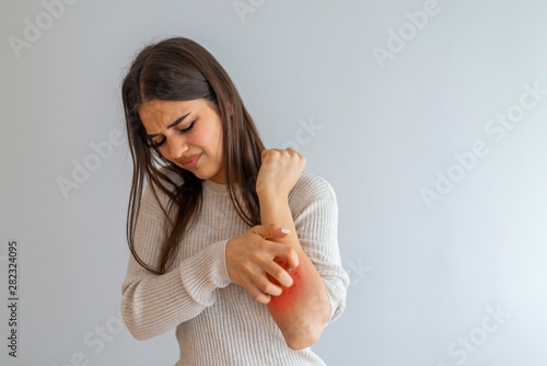 Woman Scratching an itch on white background . Sensitive Skin, Food allergy symptoms, Irritation. People scratch the itch with hand, Arm, itching, Concept with Healthcare And Medicine.